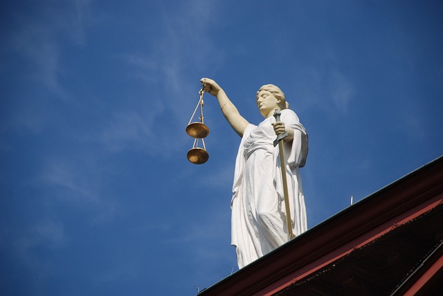 estatua de la justicia con un cielo azul claro detrás
