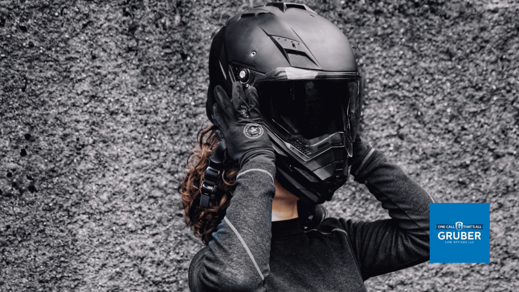 Woman putting on a motorcycle helmet - Gruber Law