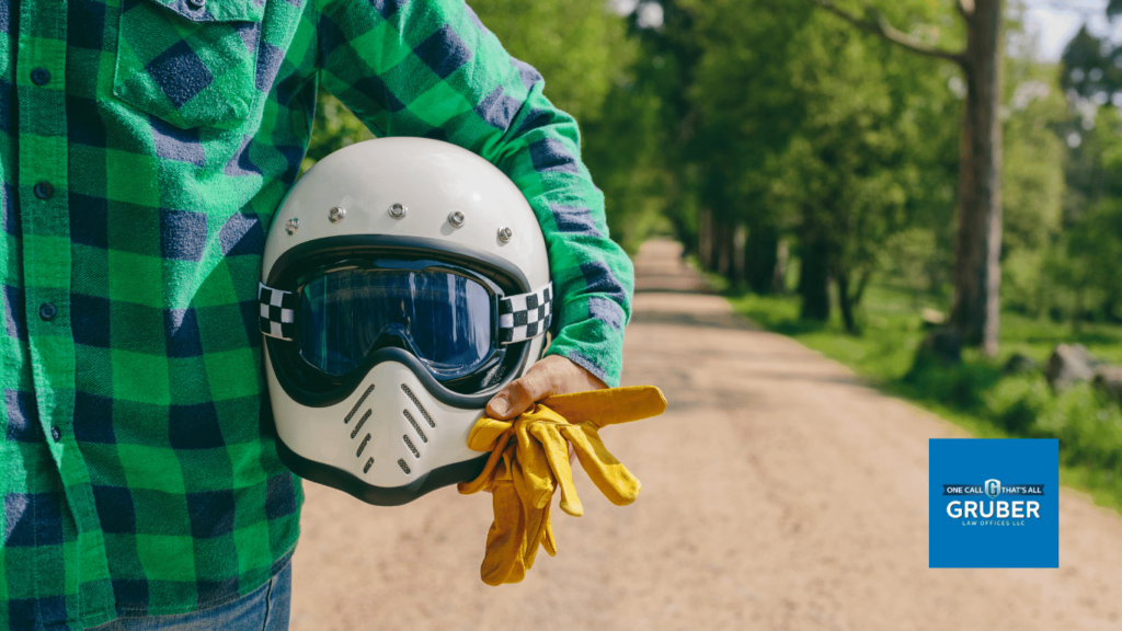man holding helmet and gloves for motorcycle - Gruber Law