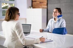 Woman in neck brace and arm sling talks to Milwaukee truck accident lawyer