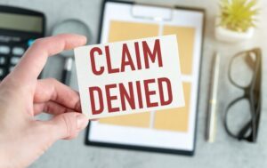 A person holds a card that says "claim denied." If your truck accident claim has been denied, read the denial letter to find out why, and then consult an attorney who can help you challenge the denial.