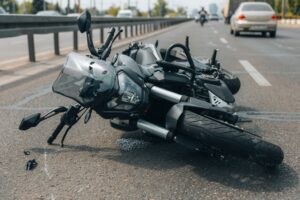 A crashed motorcycle lies on the road, prompting the question: Are motorcycle accident settlements taxable in Wisconsin?