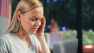 Woman rubbing temple wondering what are symptoms of a brain injury after an auto accident