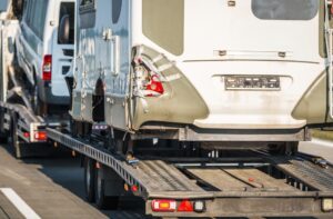 A tow truck removes an RV from the scene of a collision.