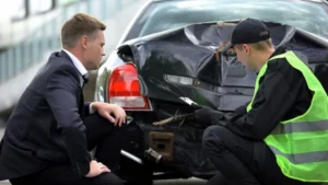 A police officer and motorist review a damaged car after an accident in Green Bay, Wisconsin. You can get a car accident report by requesting a copy from the Green Bay Police Department, either online, by mail, or in person.
