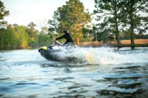 A person rides a jet ski on the water, leading them to wonder who is liable for a jet ski accident.