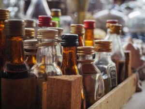 Jars of liquor held for sale on a dram shop shelf.