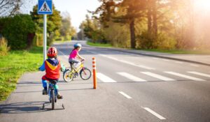 A child rides a bicycle across a pedestrian walkway.